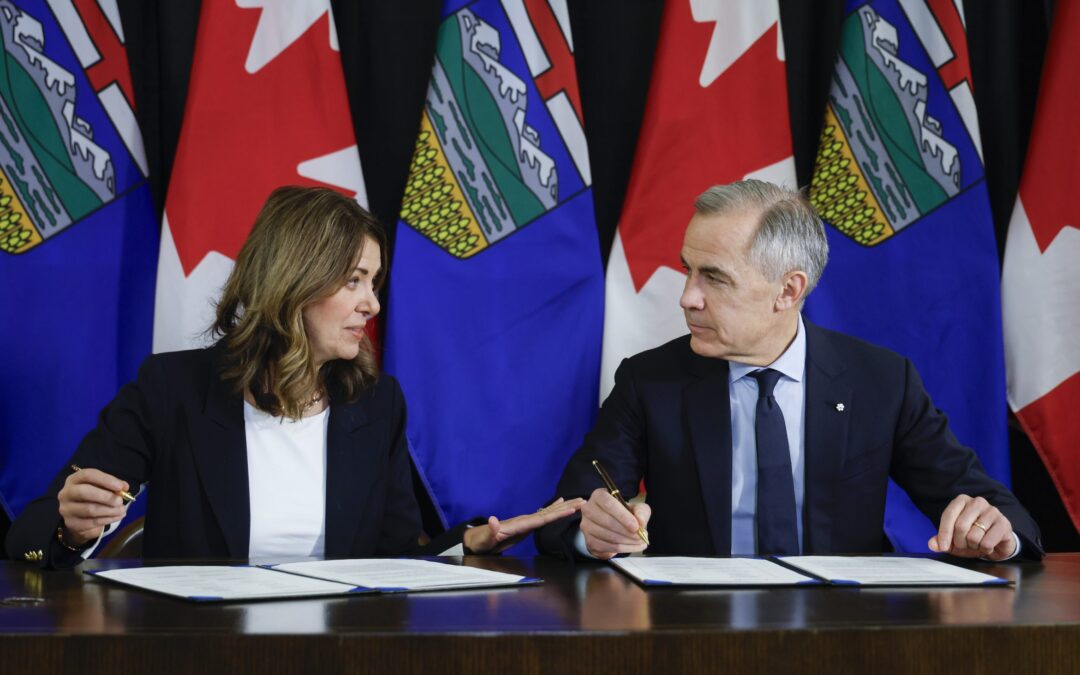 Prime Minister Mark Carney, right, signs an MOU with Alberta Premier Danielle Smith in Calgary, Alta., Thursday, Nov. 27, 2025. THE CANADIAN PRESS/Jeff McIntosh